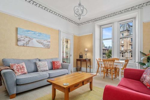 a living room with a couch and a table at Stunning 2BR Apt - Central, Argyll Square Views in Oban
