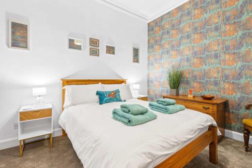 a bedroom with a bed with two towels on it at Stunning 2BR Apt - Central, Argyll Square Views in Oban