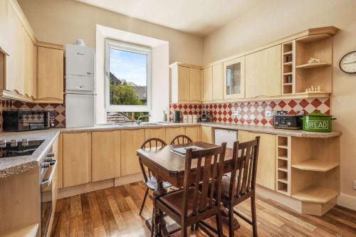 a kitchen with a table and chairs and a window at Stunning 2BR Apt - Central, Argyll Square Views in Oban