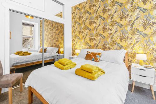 a bedroom with a large bed with yellow towels on it at Stunning 2BR Apt - Central, Argyll Square Views in Oban