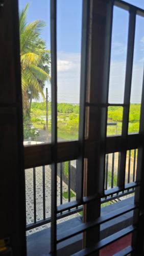 a view from a window looking out at a palm tree at Ramiy Resort Batticaloa in Batticaloa