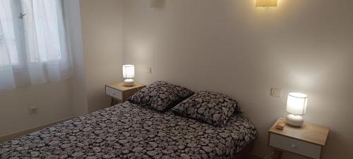 une petite chambre avec un lit et deux tables de nuit dans l'établissement Sympathique 3 pièces, à Antibes