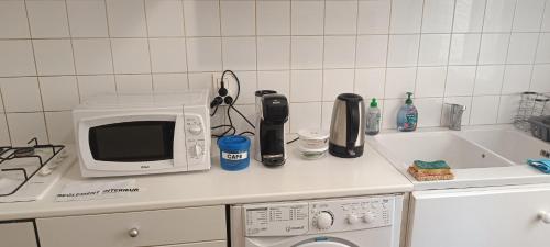 un comptoir de cuisine avec un micro-ondes et un évier dans l'établissement Sympathique 3 pièces, à Antibes