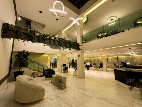 a large building with a lobby with plants on the ceilings at HVH by Yaxché in Guadalajara