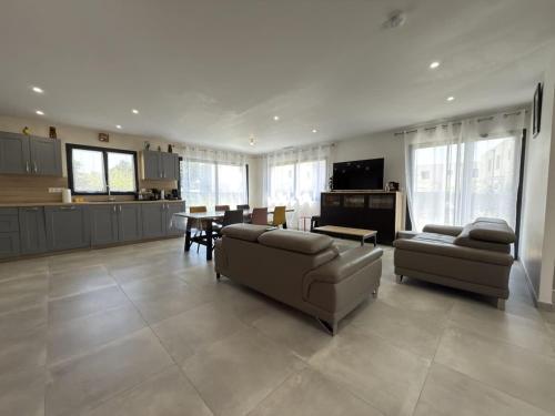 un salon avec deux canapés et une cuisine dans l'établissement Sublime villa neuve proche de la plage, à Sérignan