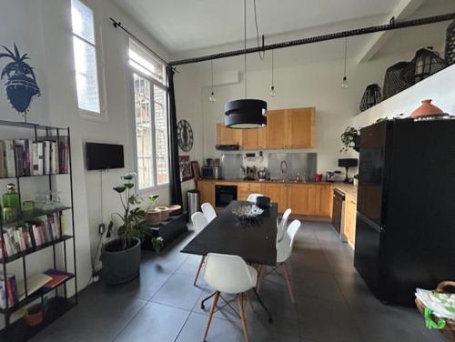 une cuisine avec une table et des chaises dans une pièce dans l'établissement Appartement Loft centre ville, à Puteaux