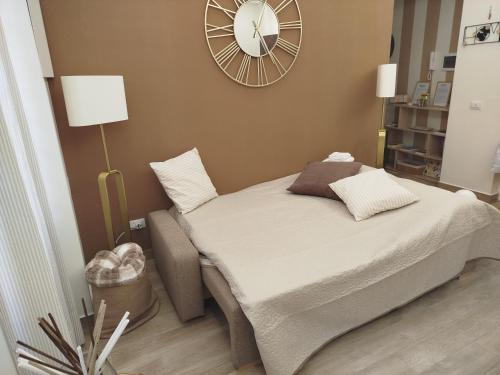 Cama en habitación con reloj en la pared en Le Rondini in giardino, en Roma