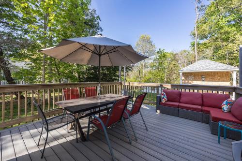 a patio with a table and chairs and an umbrella at Harwich Getaway in Harwich