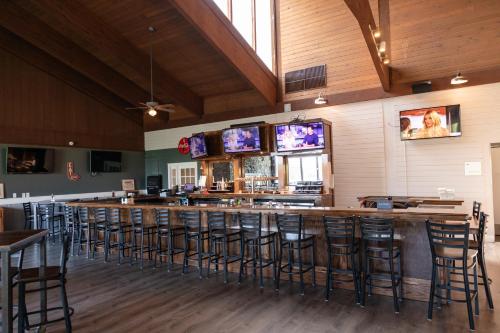a bar in a restaurant with bar stools at Hotel Cape Cod in Falmouth