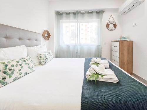 a bedroom with a large white bed and a window at Apartment Panorama Green in Portimão