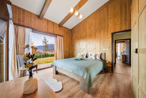 a bedroom with a bed and a large window at Pirin Golf Lux Villa for Ski & Chill in Bansko