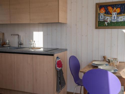 a kitchen with a sink and a table with purple chairs at Tiny house at countryside in Jõgeveste