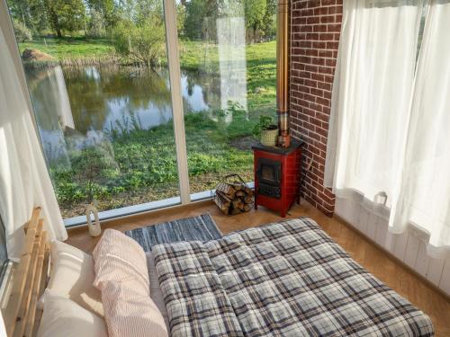 a living room with a bed and a large window at Tiny house at countryside in Jõgeveste