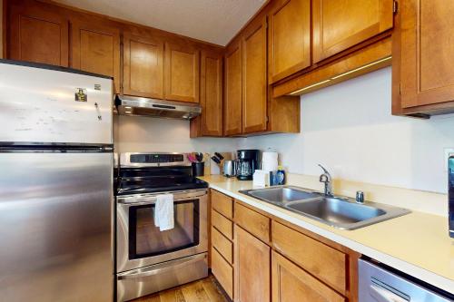 a kitchen with wooden cabinets and a stainless steel refrigerator at Basecamp Bliss in Olympic Valley