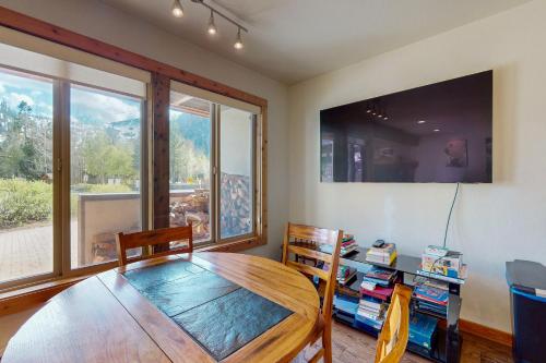 a dining room with a table and a large window at Basecamp Bliss in Olympic Valley