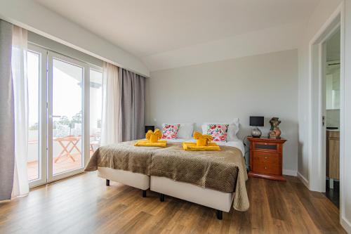 a bedroom with a bed with yellow towels on it at Vivenda da Bela Vista in Ponta Delgada
