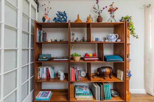 a book shelf with books and other items on it at Vivenda da Bela Vista in Ponta Delgada