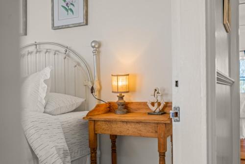 a bedroom with a bed and a table with a lamp at Charming 4BR Victorian Mystic Downtown in Groton