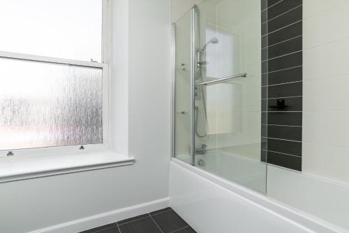 a bathroom with a shower and a glass window at Central comfort and explore nearby cafes in Aberdeen