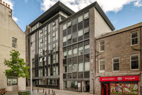 an old brick building with a black roof at Central comfort and explore nearby cafes in Aberdeen