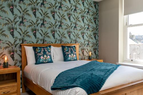 a bedroom with a bed with a floral wallpaper at Central comfort and explore nearby cafes in Aberdeen