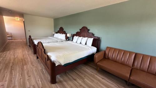 a hotel room with two beds and a couch at The Shelby Inn in Shelbyville