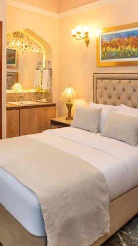 a bedroom with a large bed and a bathroom at Hotel Boutique Patio Andaluz Cali Granada in Cali