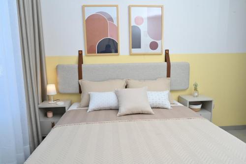 a bedroom with a large bed with three pictures on the wall at Serenity Palmas- in Santa Cruz de la Sierra