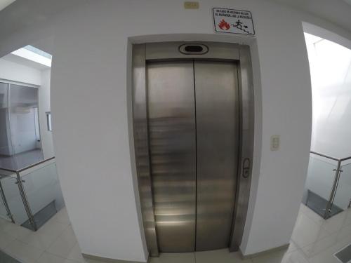 a metal elevator in a building with a sign on it at Serenity Palmas- in Santa Cruz de la Sierra