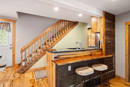 a kitchen with wooden stairs and a sink at Updated townhome - Walk to Holiday Valley in Ellicottville
