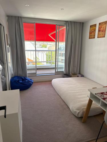 une chambre avec un grand lit et une grande fenêtre dans l'établissement Terrasse tour, à Paris