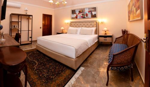 a bedroom with a bed and a table and a chair at Hotel Boutique Patio Andaluz Cali Granada in Cali