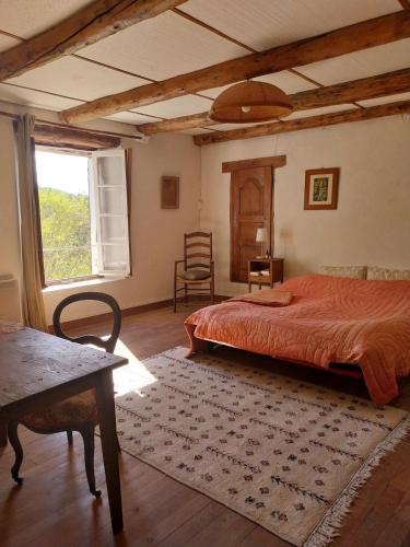 une chambre avec un lit, une fenêtre et une chaise dans l'établissement Maison Authentique en Ubaye, à Jausiers