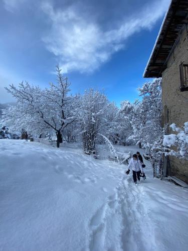 a person walking down a snow covered road at Maison Authentique en Ubaye in Jausiers