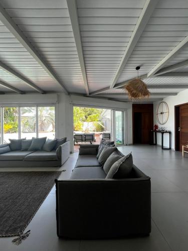 a large living room with couches and a ceiling at Red tree villa in Montjoly
