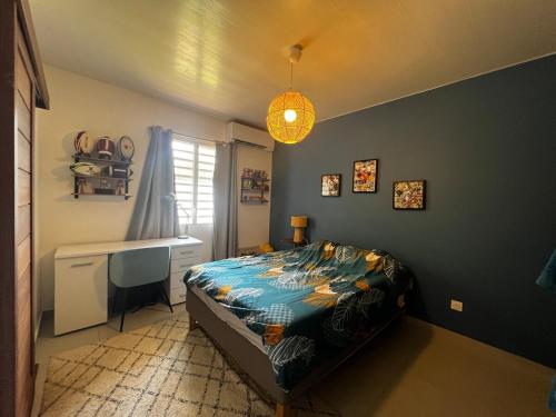 a bedroom with a bed and a desk in it at Red tree villa in Montjoly