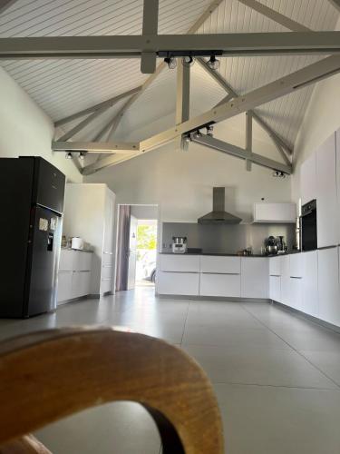 a kitchen with white cabinets and a black refrigerator at Red tree villa in Montjoly