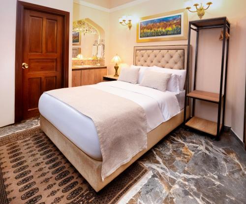 a bedroom with a large bed and a bathroom at Hotel Boutique Patio Andaluz Cali Granada in Cali