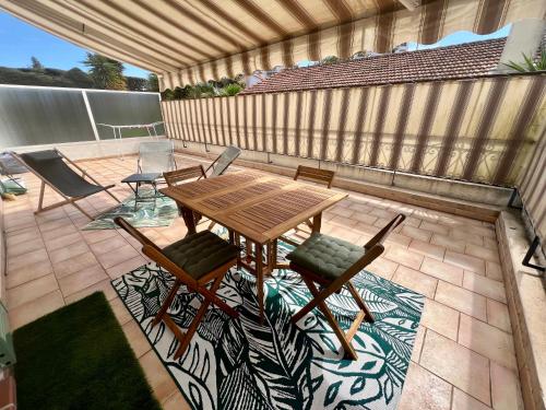 a wooden table and chairs on a patio at Charmant 2 pièces, terrasse 30m2 in Antibes