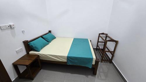 a bed with blue pillows and a ladder in a room at Ramiy Resort Batticaloa in Batticaloa