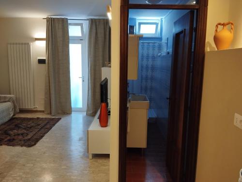 a living room with a television on a dresser and a mirror at Casetta Nel Borgo in Sestri Levante