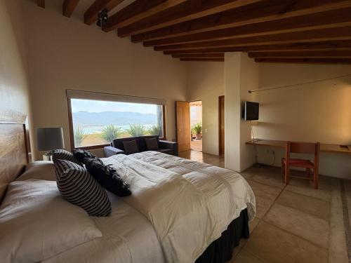 a bedroom with a large bed with a large window at Luxury with Lake View, Pool, Jacuzzi & Gym in Valle de Bravo