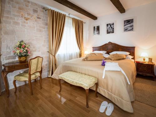 1 dormitorio con 1 cama, mesa y silla en Priska Heritage Rooms, en Split