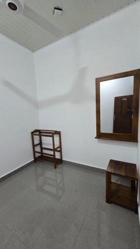 a white room with a mirror and a wooden table at Ramiy Resort Batticaloa in Batticaloa