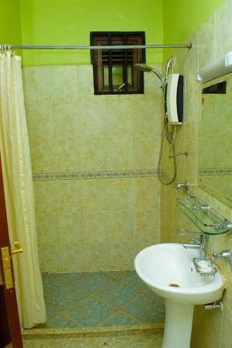 a bathroom with a sink and a shower at new raya hotel in Nairobi