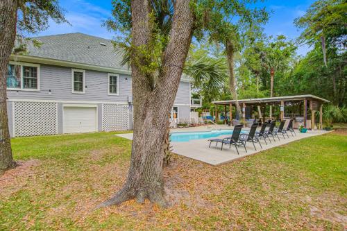a house with a pool and chairs in the yard at Edisto Hidden Oasis in Edisto Island