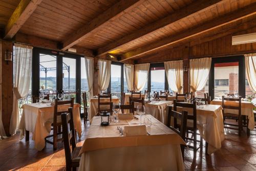 a dining room with tables and chairs and windows at Il Conte Matto in Trequanda
