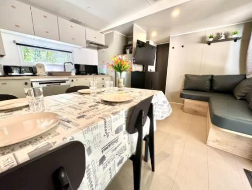 une cuisine et un salon avec une table et un canapé dans l'établissement Ruoms Mobil-home camping animé près des Gorges, à Lagorce