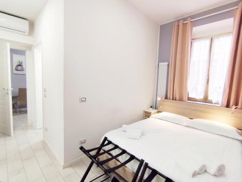 a white bedroom with a bed and a window at Rho Fiera Milano - Onit's apartment in Pero