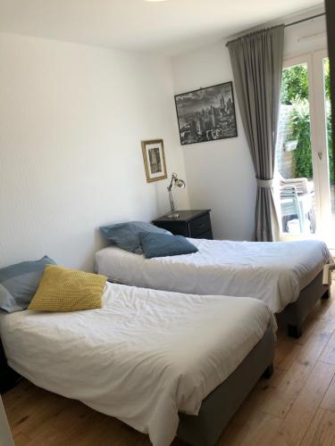 deux lits assis dans une pièce avec une fenêtre dans l'établissement Beau T3 Solidor avec Terrasse à 50m de la mer, à Saint-Malo